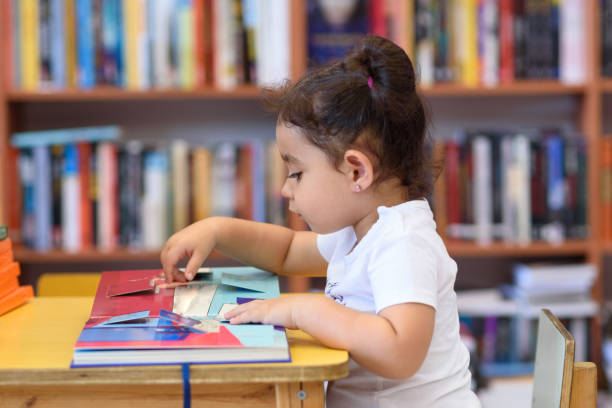 istock Happy child little girl reading a book. 1154573184