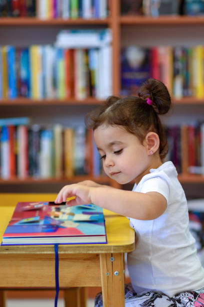 istock Happy child little girl reading a book. 1154573191
