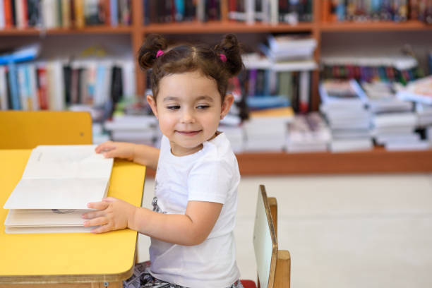 istock Happy child little girl reading a book. 1154573207