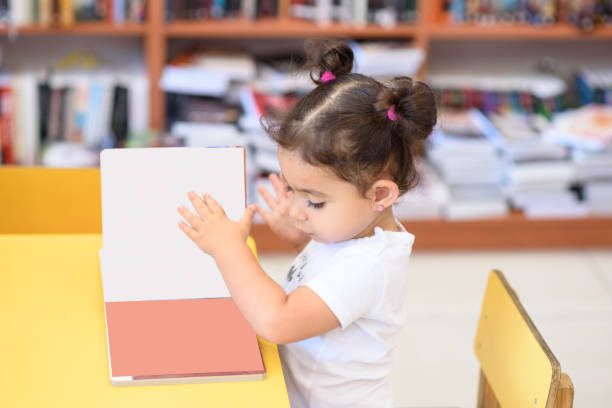 istock Happy child little girl reading a book. 1154573257