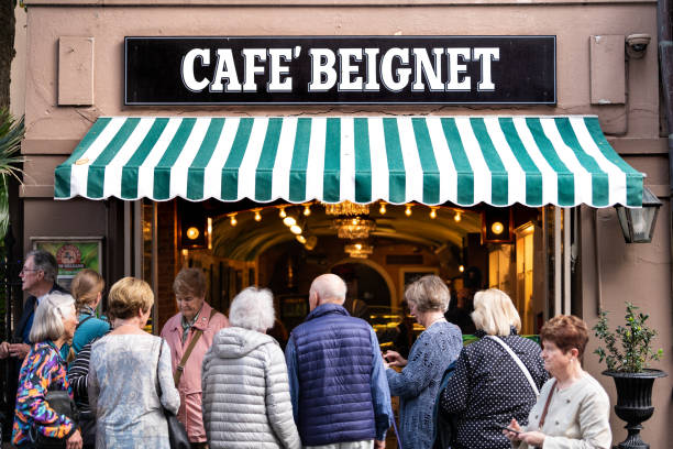 New Orleans, USA - April 23, 2018: People in line queue during day for famous restaurant cafe beignet powdered sugar donuts