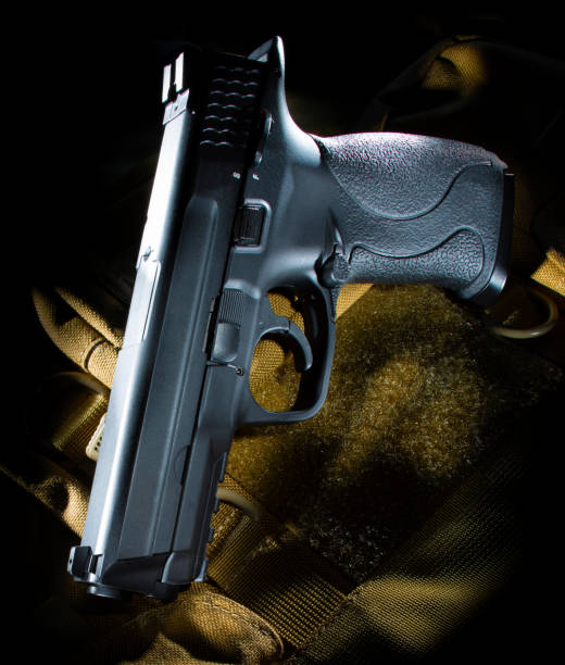 istock Semi automatic handgun on a tan tactical bag 1154583264