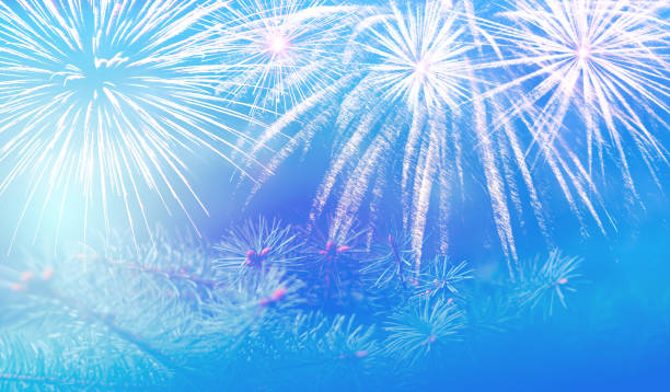 istock Christmas pine branch on a beautiful blue background with sparks and fireworks splashes, wonderful New Year's mood 1154585807