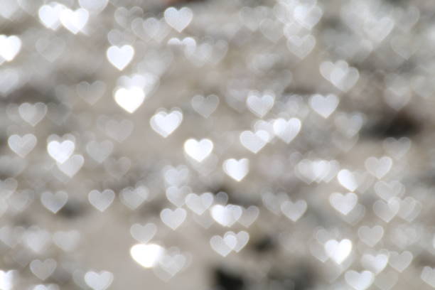 istock White bokeh Heart-shaped lights reflecting on the wet muddy ground. White silver bokeh background love abstract, love wet soil ground nature 1154586491