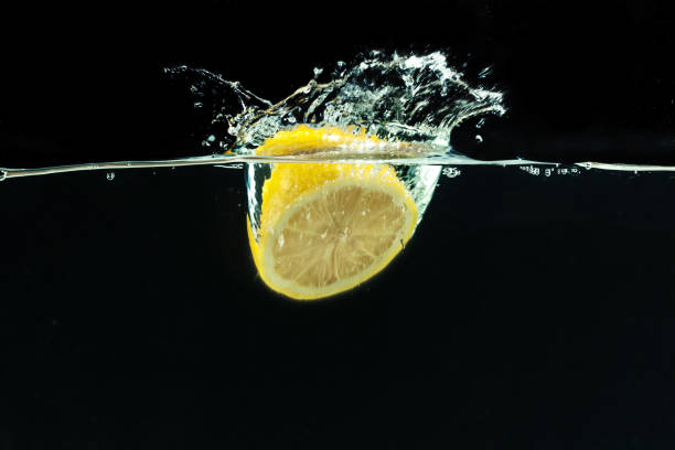istock fresh yellow lemon in water splash on black background 1154587436