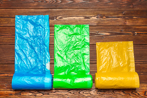 Different plastic bags on wooden background.