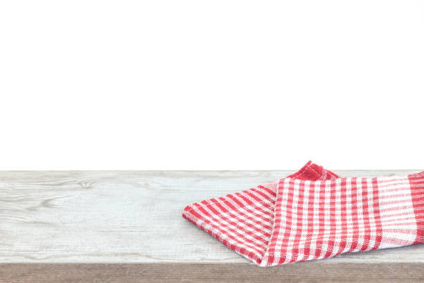 istock Empty wooden desk table and red checked tablecloth over mint wallpaper background 1154587825