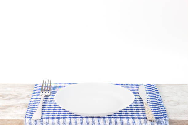 istock Empty plate on tablecloth or napkin on wooden table over cement background 1154587850