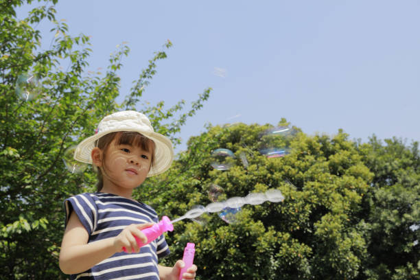 Japanese girl playing with bubble under the blue sky (4 years old)