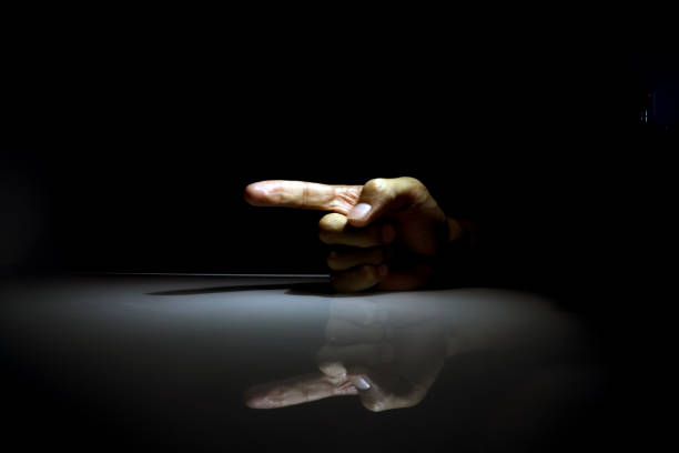 istock A male hand with index finger pointing left. Finger reflected on the glass table. 1154588744