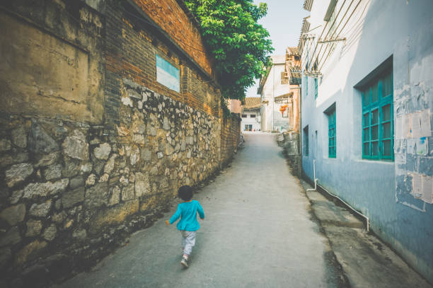 A Chinese little girl run in the Chinese ancient town street.