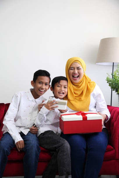 istock mother's day son giving present to mother 1154595477
