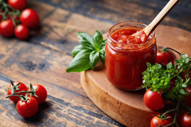 sos pomidorowy w szklanym słoiku, pomidory i zioła na boku. - tomato sauce jar zdjęcia i obrazy z banku zdjęć