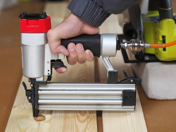 istock Air Nailer, Stapler pneumatic work with hand controls. Carpenter fix clapboard 1154600634