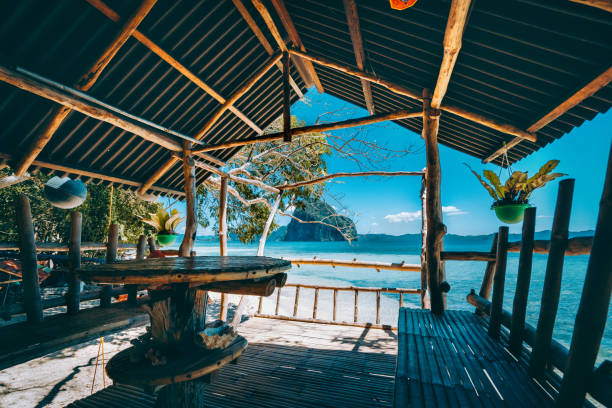 Tropical getaway remote panorama of impressive Pinagbuyutan island from the native wood and bamboo terrace, beauty of Philippines island. Tropical getaway remote panorama of impressive Pinagbuyutan island from the native wood and bamboo terrace, beauty of Philippines island. summer fashion philippines palawan stock pictures, royalty-free photos & images