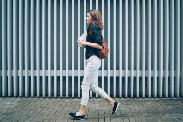 istock Woman walking on street and holding documents, side view 1154603164