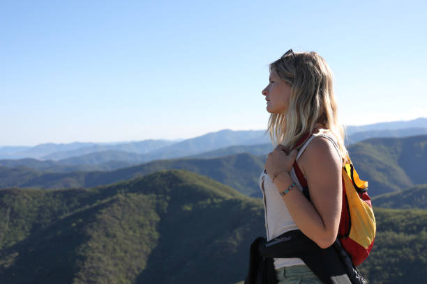istock Female hiker lost in thought above mountain range 1154603626