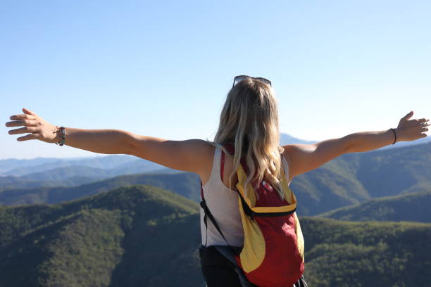 o caminhante fêmea estica seus braços acima da escala de montanha - on top of reaching mountain arms outstretched - fotografias e filmes do acervo