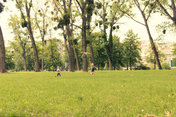 Little boy and girl having fun with their teenage friend while having fun in nature.