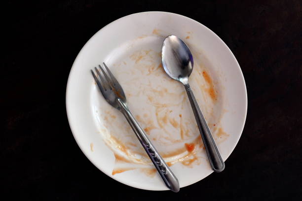 istock empty and dirty dish after eating food, plate fork and spoon 1154608010