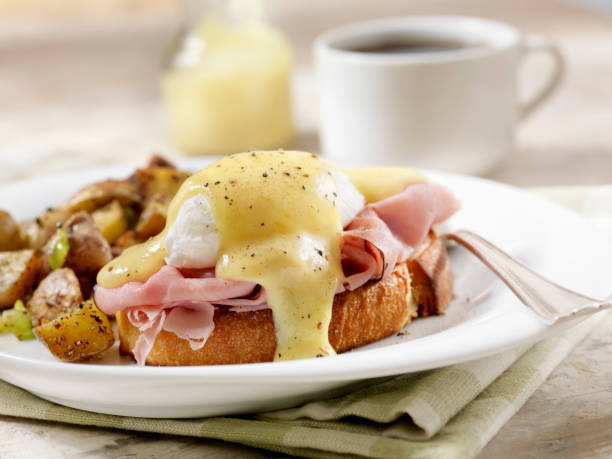 eggs benedict with black forest ham and hash browns on grilled french bread - hollandaise sauce imagens e fotografias de stock