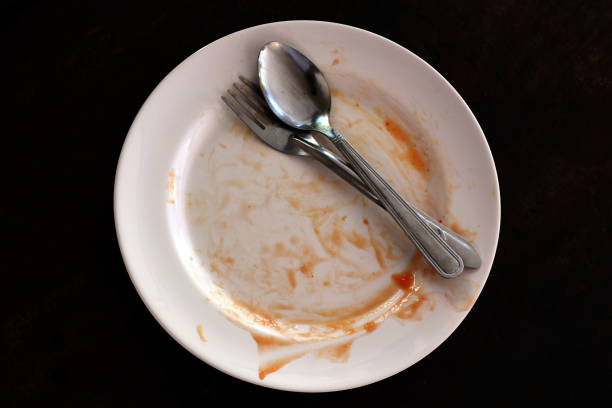 istock empty and dirty dish after eating food, plate fork and spoon 1154609477
