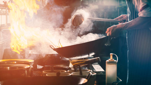 istock Chef stir fry in wok 1154613294