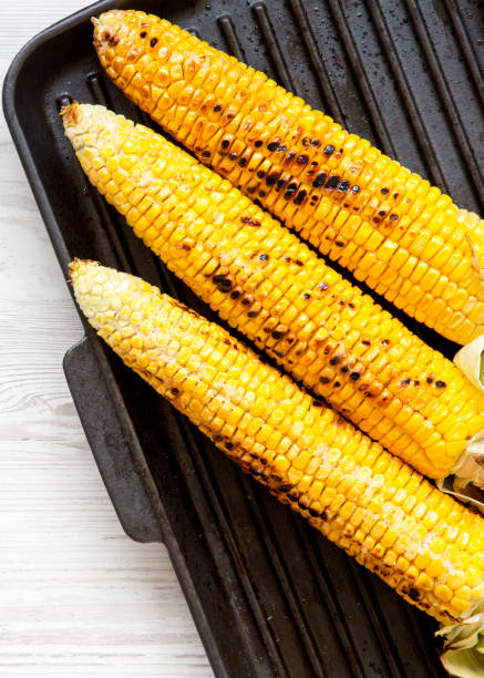 istock Grilled corn on the cob in a grilling pan, top view. Overhead, from above, flat lay. 1154615110