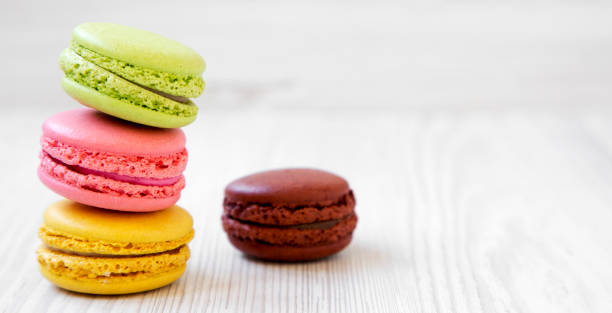 istock Sweet and colorful macarons on a white wooden surface, side view. Copy space. 1154615562