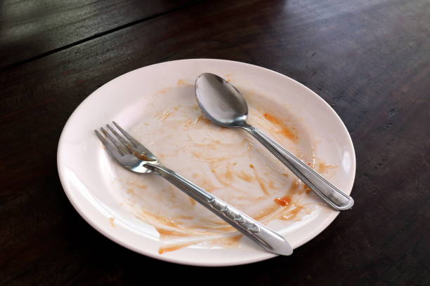 istock empty and dirty dish after eating food, plate fork and spoon 1154616130
