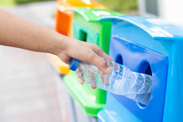 istock People are throwing empty plastic bottles into recycling bins. 1154619786