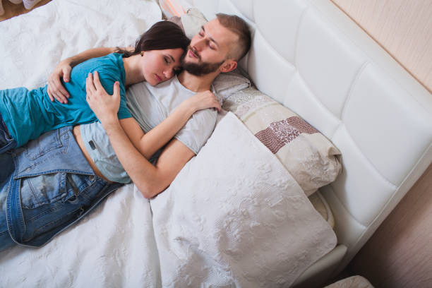 istock couple embracing lying in bed 1154620044