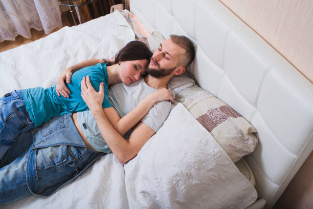 istock couple embracing lying in bed 1154620057