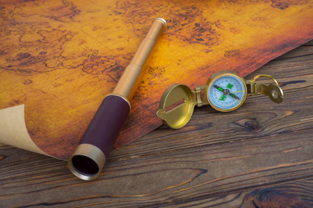 istock Spyglass, compass and old map on wooden background. 1154623090