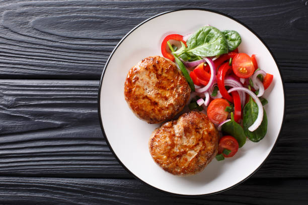 crepinette di polpette di carne francesi servite con insalata di verdure fresche da vicino. vista superiore orizzontale - turkey burger foto e immagini stock