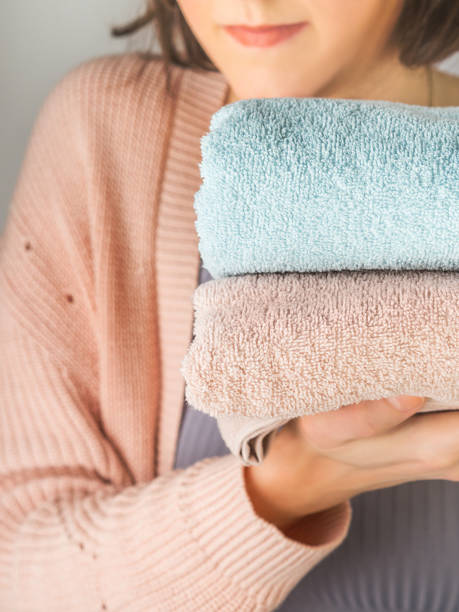istock Woman holding clean folded towels 1154628168