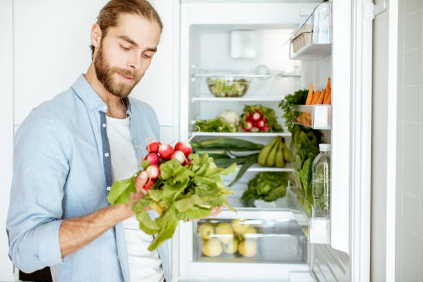 istock Man with fresh vegetables at the kitchen 1154631903