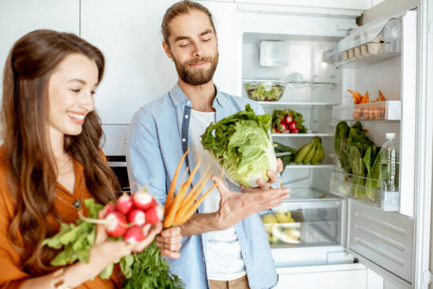 istock Vegan couple with fresh vegatables at the kitchen 1154631940