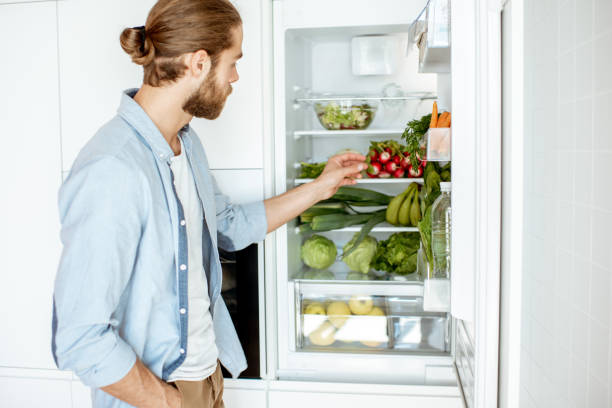 istock Man with fresh vegetables at the kitchen 1154631953