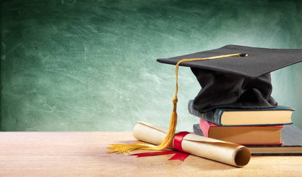 abitur cap and diploma am tisch mit büchern - universit ät stock-fotos und bilder
