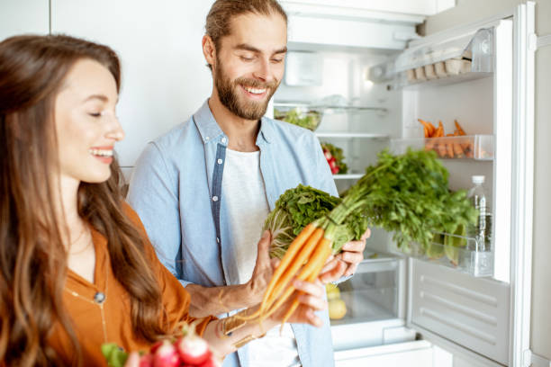 istock Vegan couple with fresh vegatables at the kitchen 1154632012