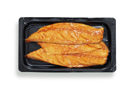 Smoked mackerel fillets in black retail tray, shot from above, isolated on white with path