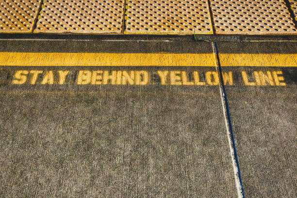 istock Stay behind yellow line sidewalk paint 1154635720