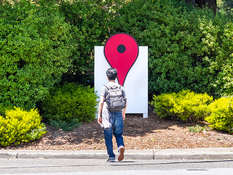 June 4, 2019 Mountain View / CA / USA - The Google Maps Icon near their offices in the Google campus (Googleplex) in Silicon Valley; employee crossing the street; south San Francisco bay area