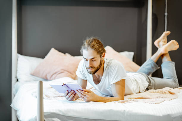 istock Man reading book in the bedroom 1154639490