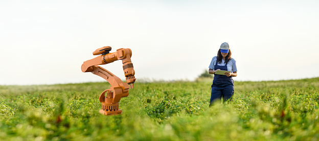 Young female farmer operating smart-farming robot