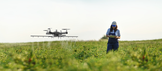 Female farmer using a drone to spray her crops