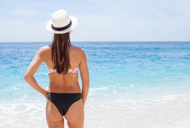 istock beautiful young woman at the beach 1154642670