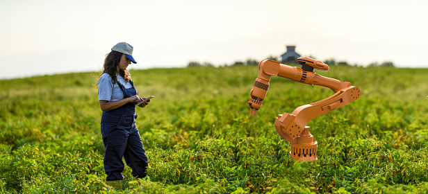 Young female farmer operating smart-farming robot