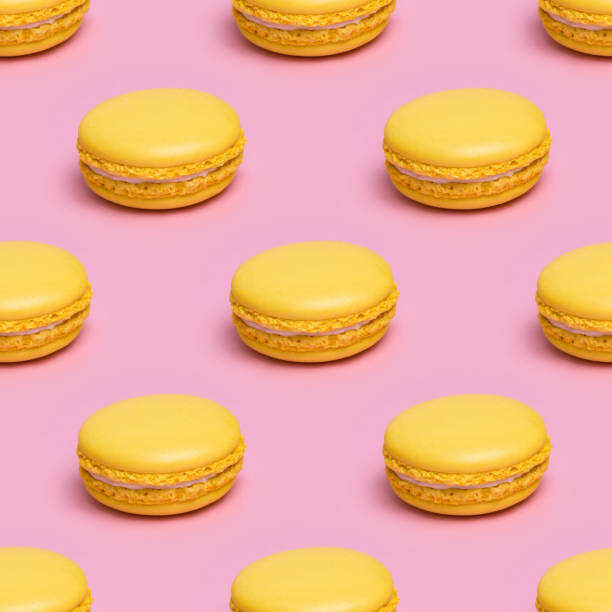 Seamless pattern with yellow macaron cookies on a pink background.